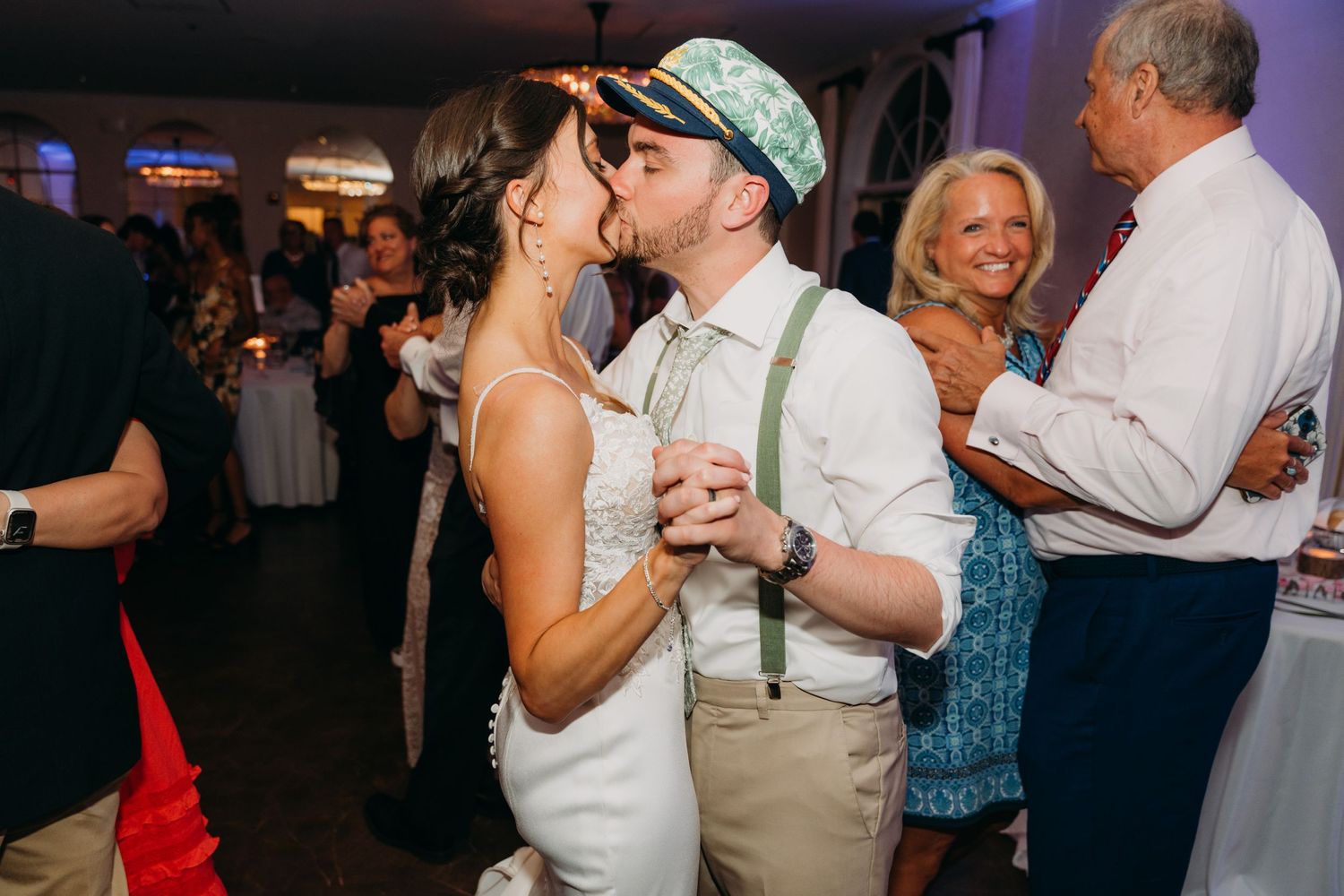 Wedding party members dancing together during an evening celebration.