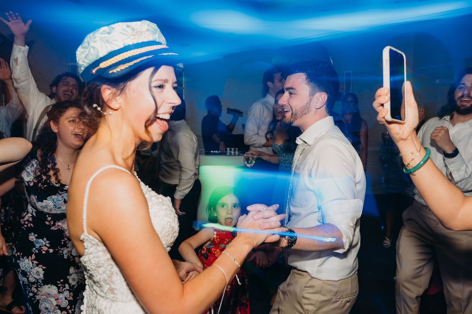 Wedding celebration on the dance floor with blue lighting and festive atmosphere.