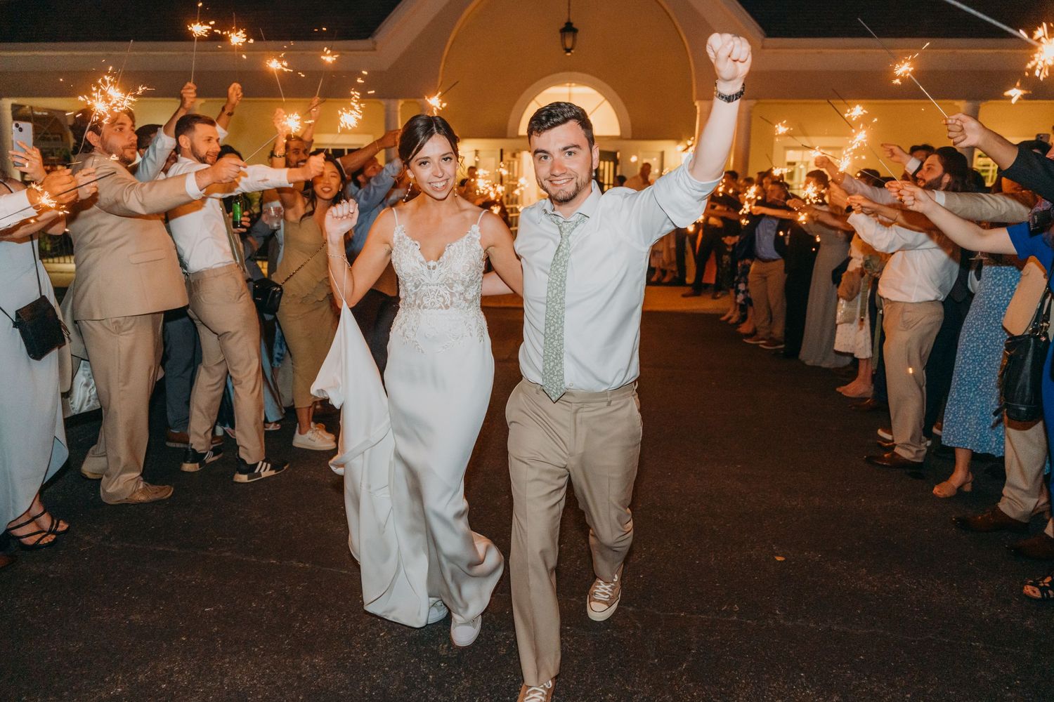 Celebration on the dance floor with guests lined up along the sides of the venue.