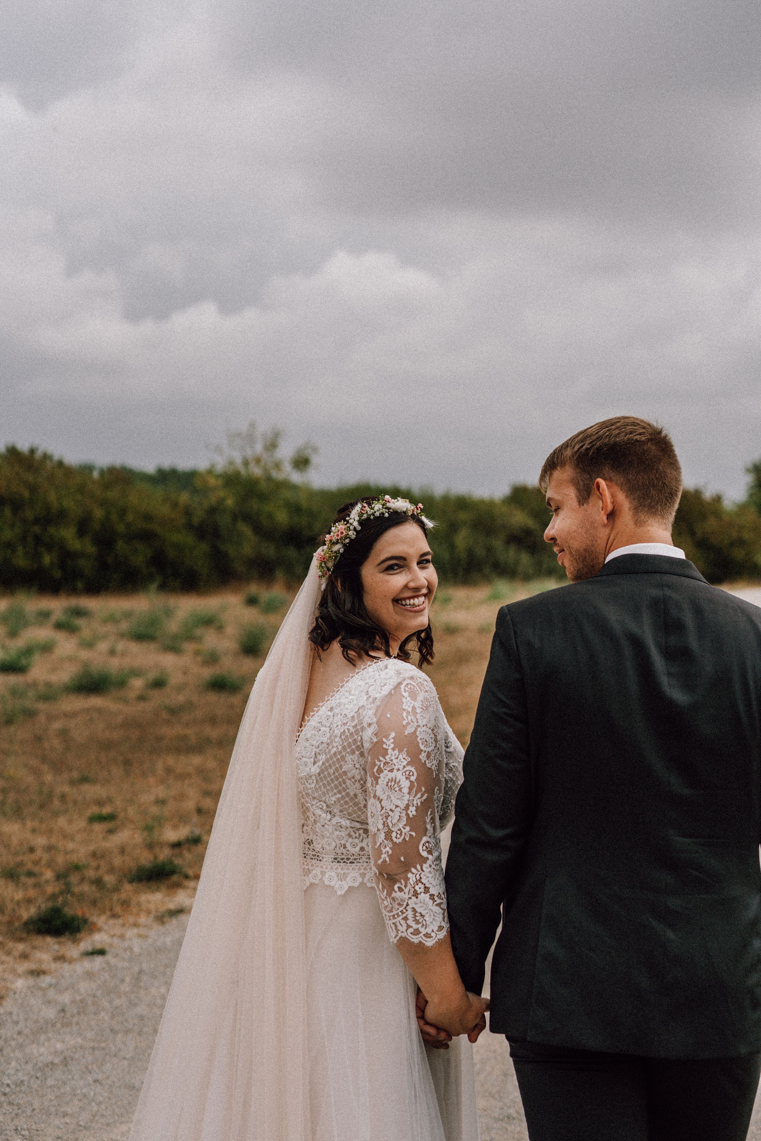 Wedding couple sharing a tender moment on a cloudy country road.