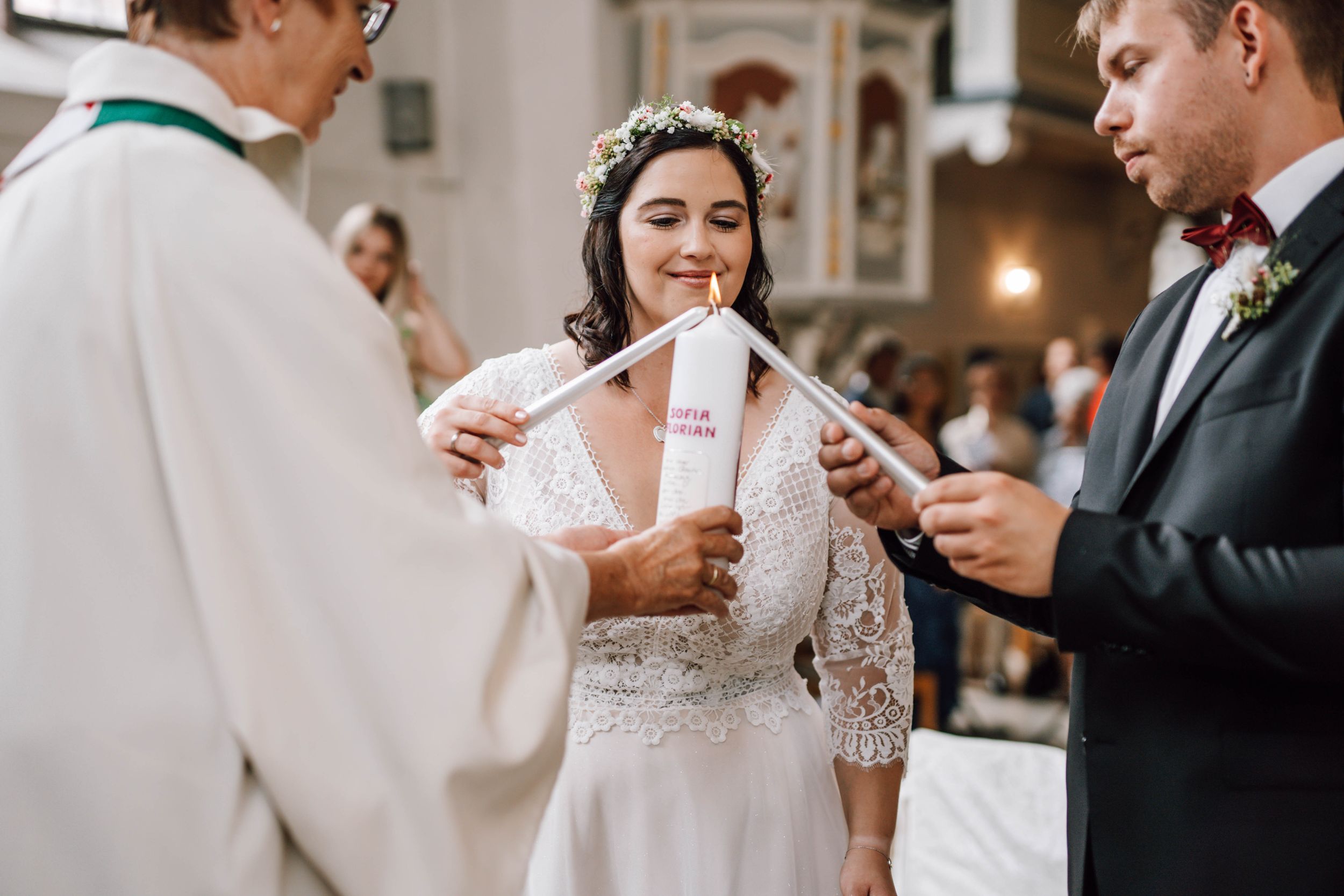 A couple shares their first kiss as newlyweds during an intimate church wedding ceremony.