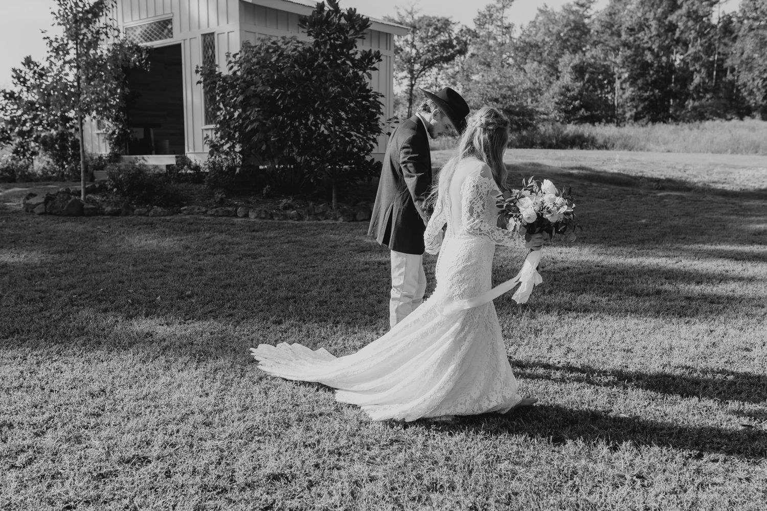 Bride and groom walking together, hand in hand, just after being married. Black and white image