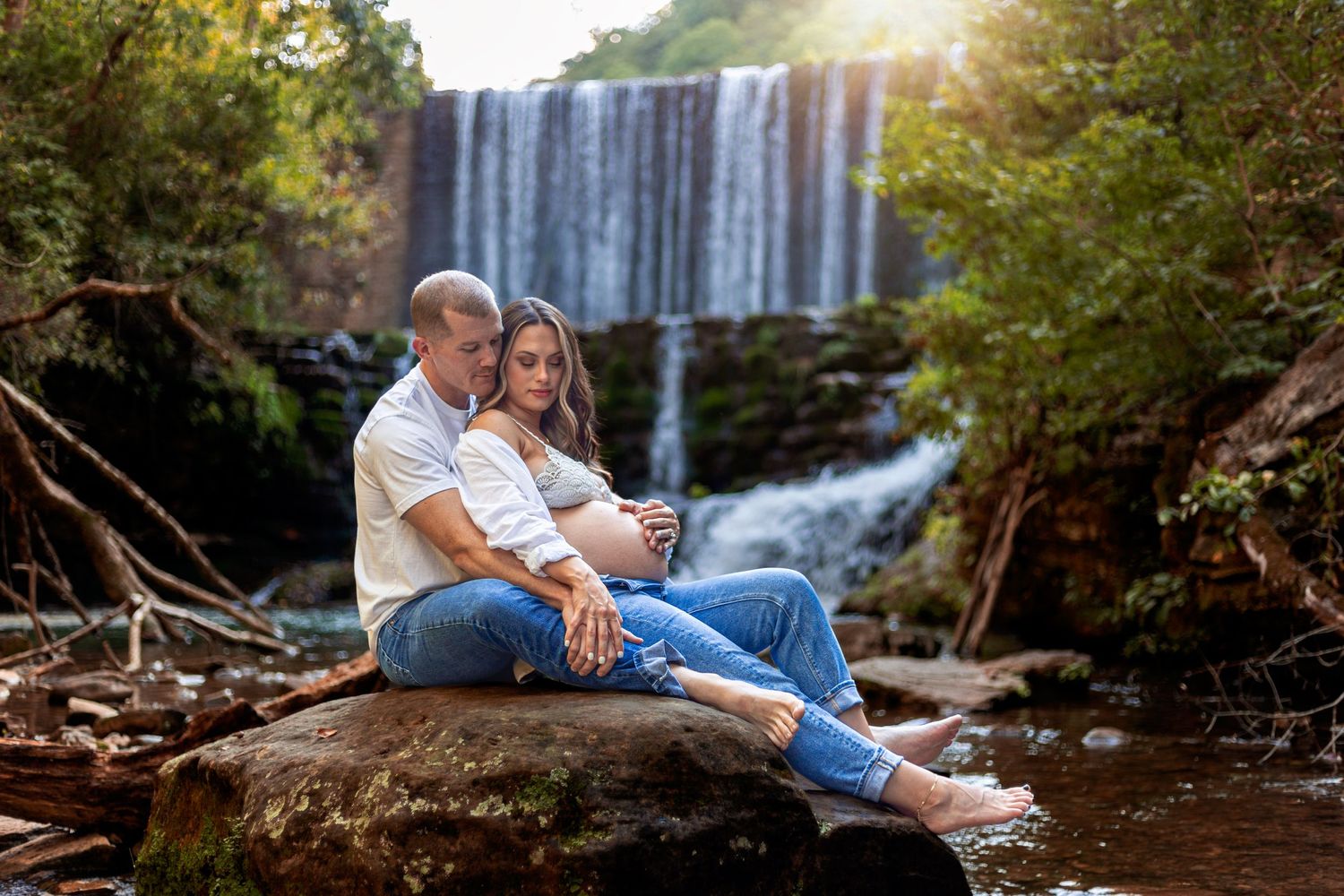 Family photoshoot at a scenic waterfall location during golden hour.