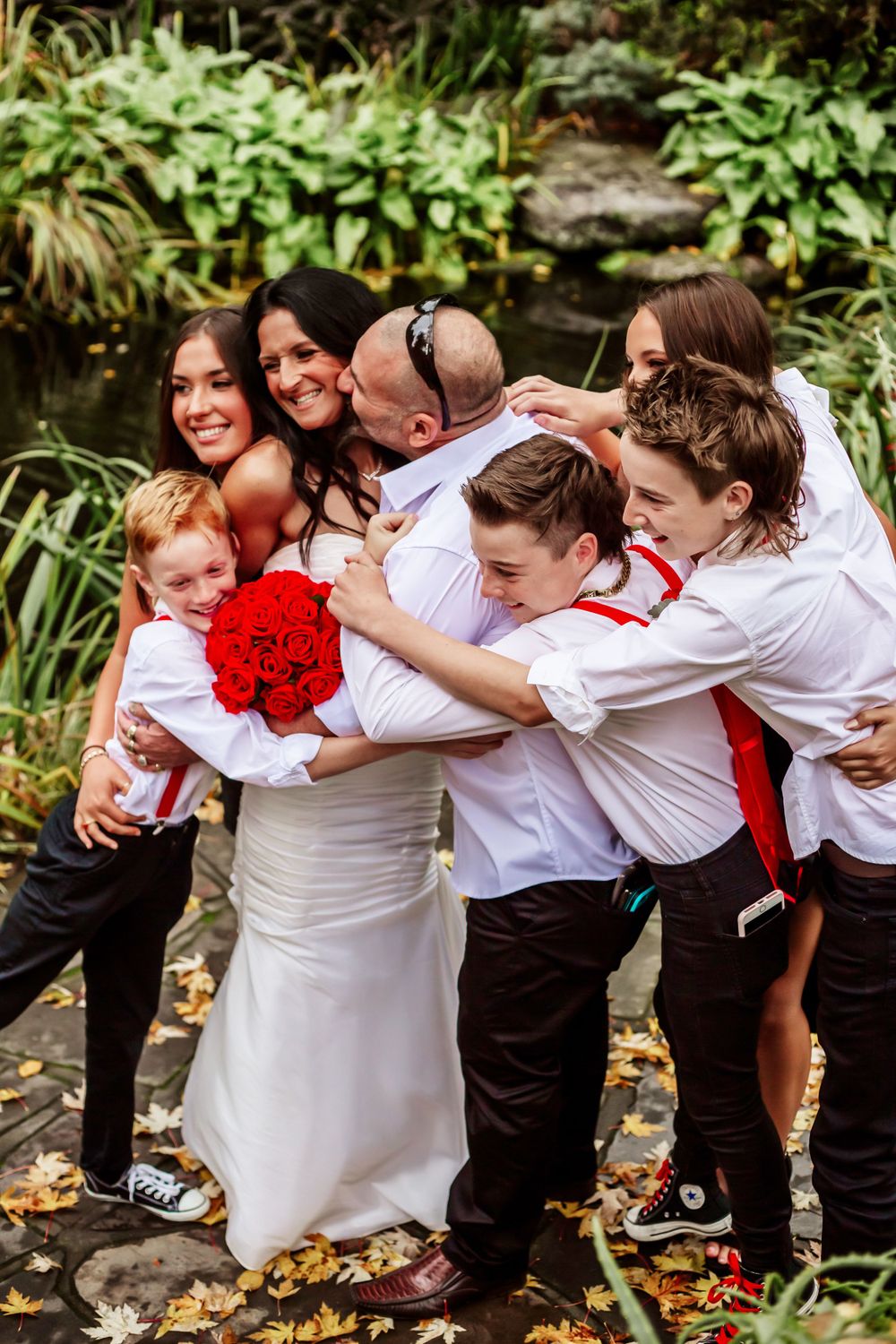 Joyful wedding party creates fun group photos with bride and attendants in coordinated attire.