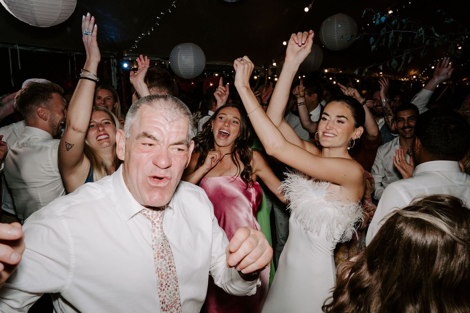 bride dancing with friends on a busy dance floor at wedding in oxfordshire