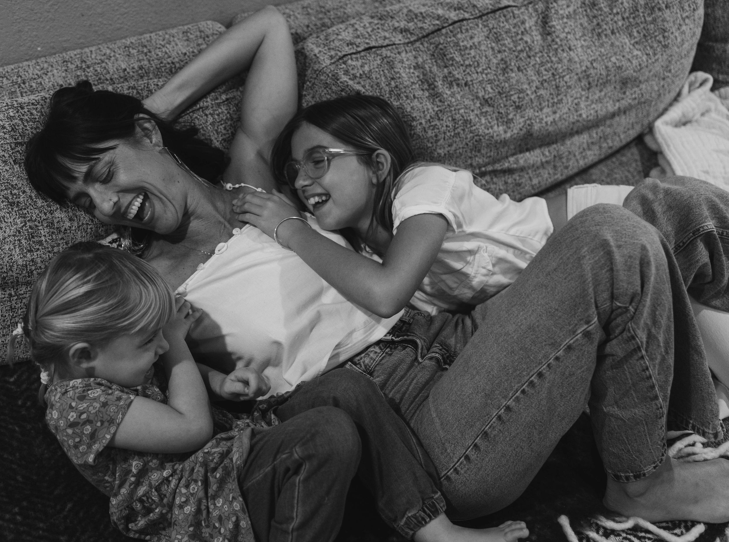 Black and white photo of people sharing a relaxed moment together on a couch.