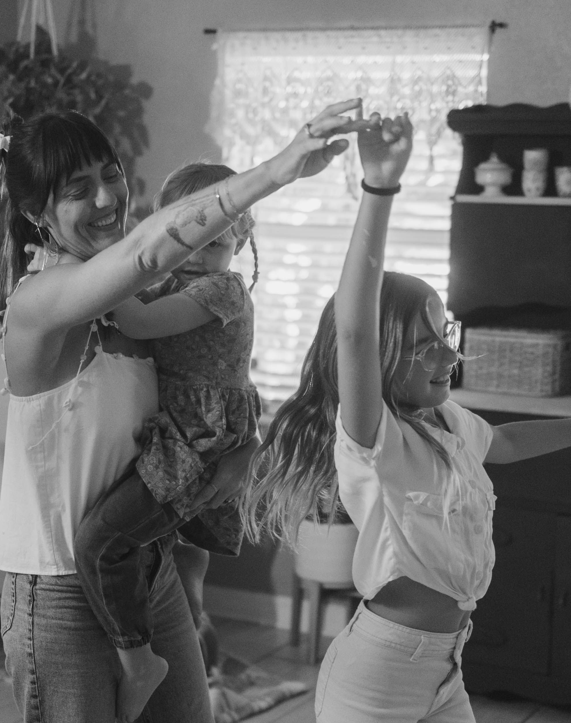 Black and white photo of people dancing and celebrating indoors.