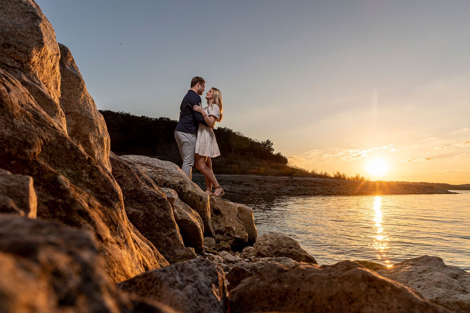 Golden hour coastal photography session with dramatic rocky cliffs and ocean views.