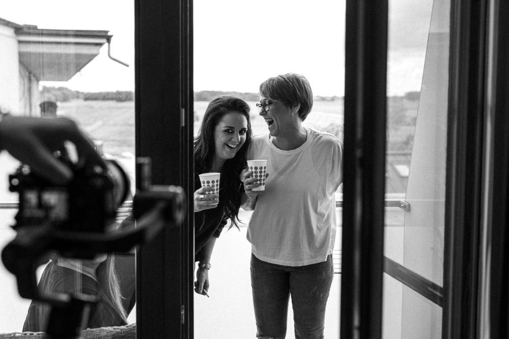 Two people share a candid laughing moment together in black and white photography.