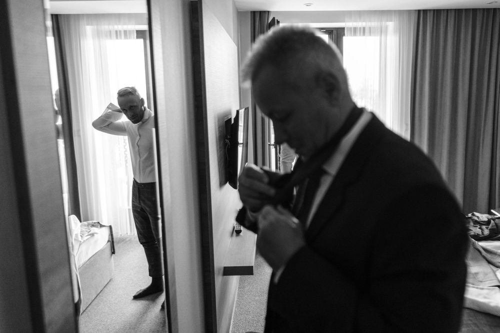Black and white image showing silhouettes getting ready in a hotel room.