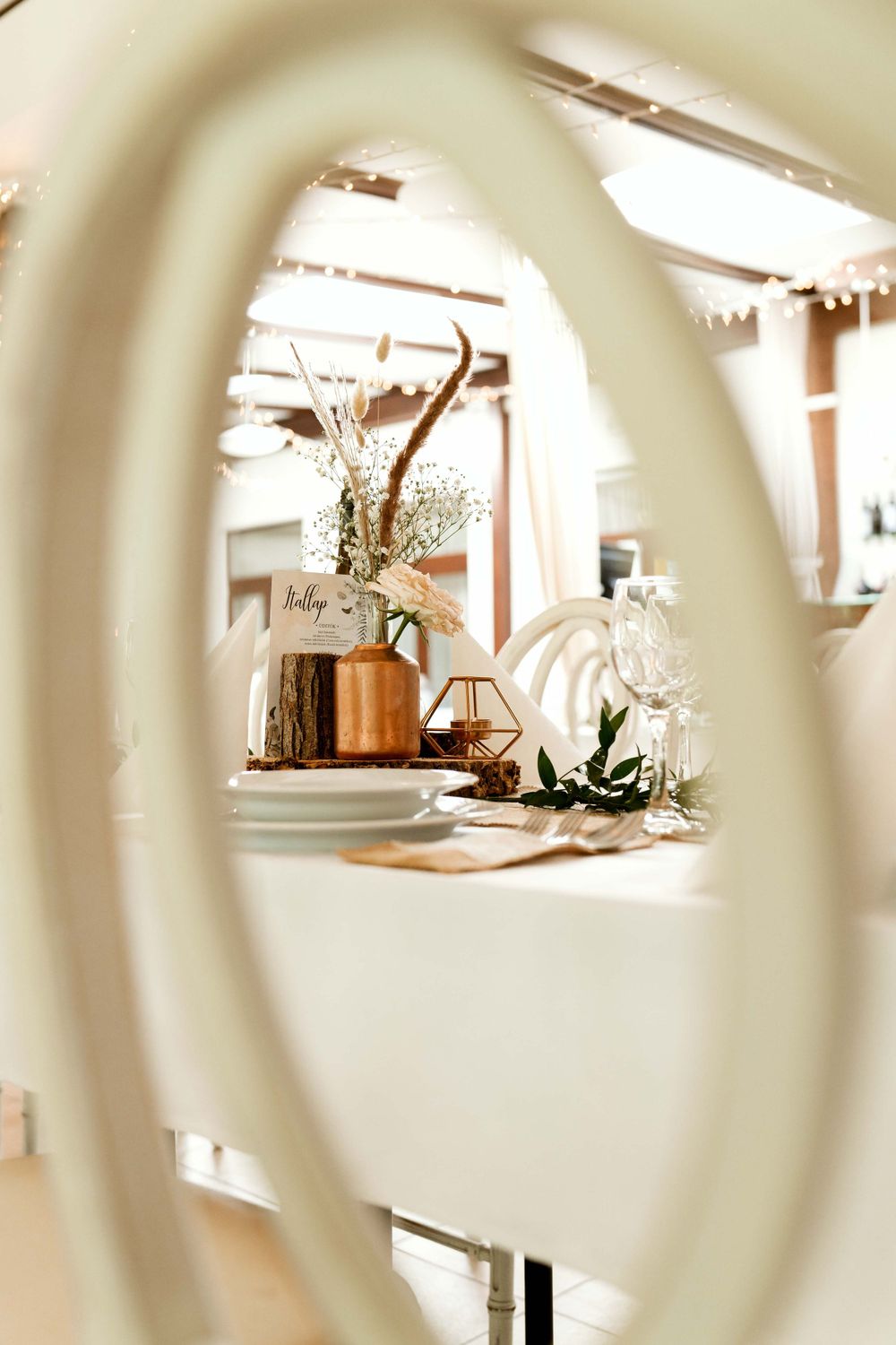 Elegant wedding decor with dried flowers and geometric terrarium centerpieces viewed through a circular frame.