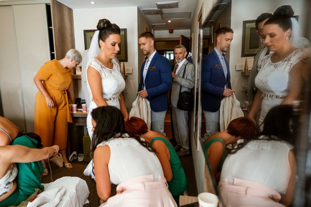 Wedding party members gathered in a hotel hallway during pre-ceremony preparations.