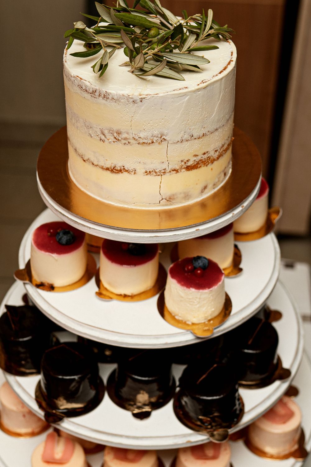 A couple cutting into a multi-tiered dessert display at their reception.