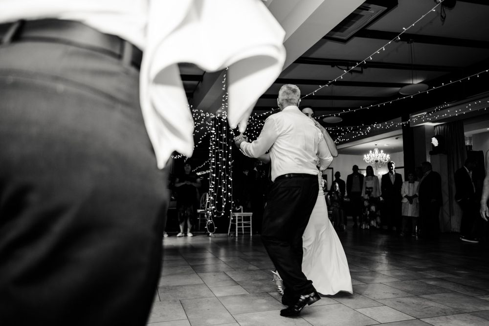 Party guests enjoying festivities in a rustic venue with string lights overhead.