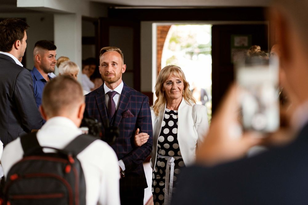 Wedding guests gathered in conversation during an indoor celebration.