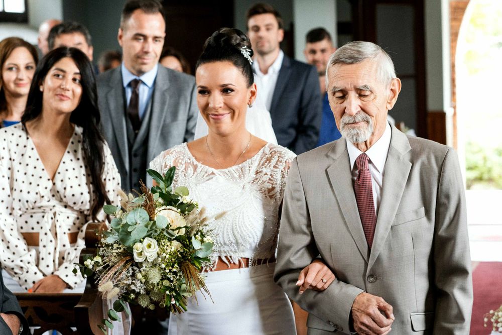 Wedding ceremony entrance with beautiful bouquet of white flowers and greenery.