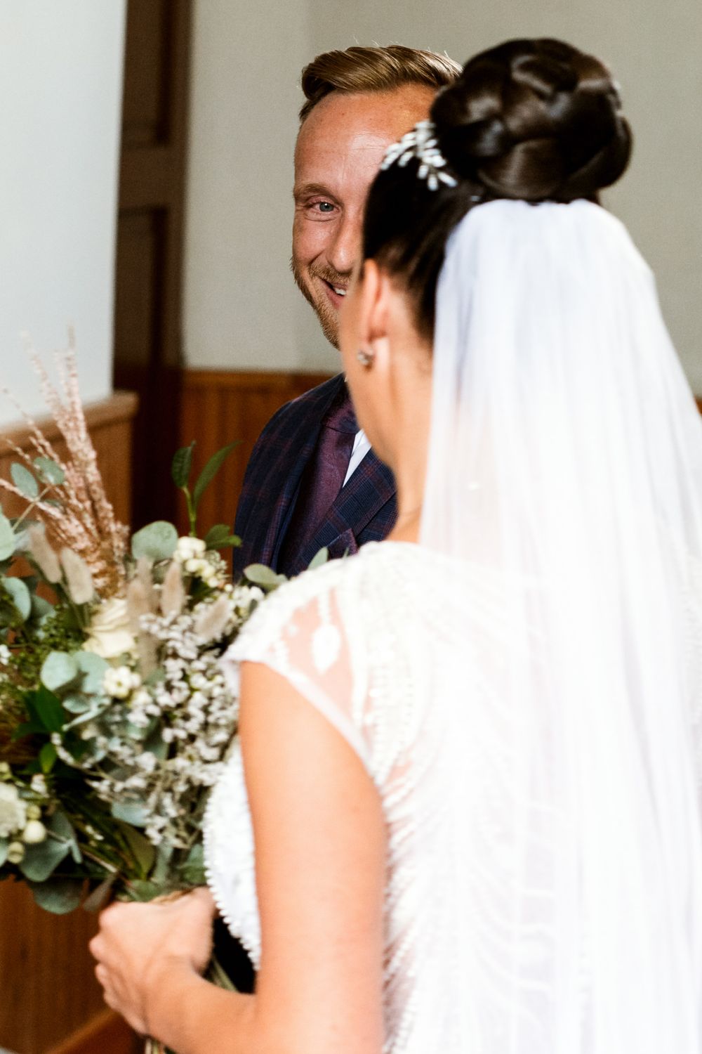 Intimate wedding ceremony moment with bridal bouquet featuring eucalyptus and white flowers.