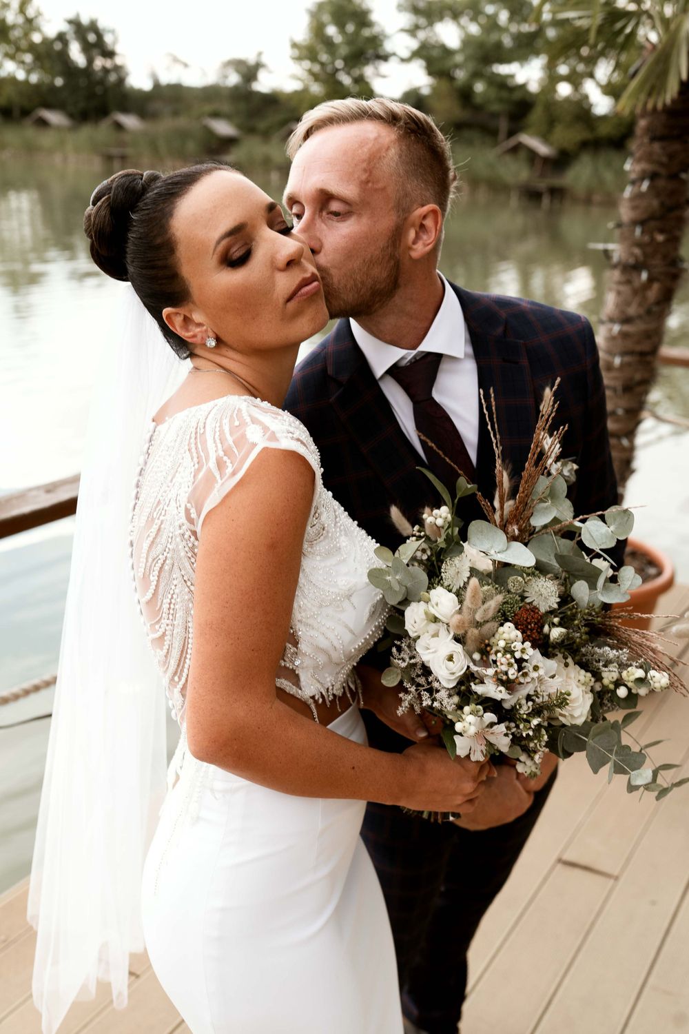 Romantic moment captured between newlyweds with elegant floral bouquet.