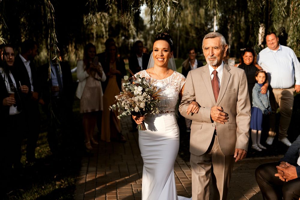 A wedding ceremony processional at an outdoor waterfront venue.