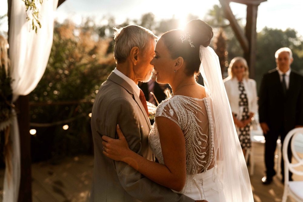 A romantic sunset moment at a waterfront wedding ceremony.