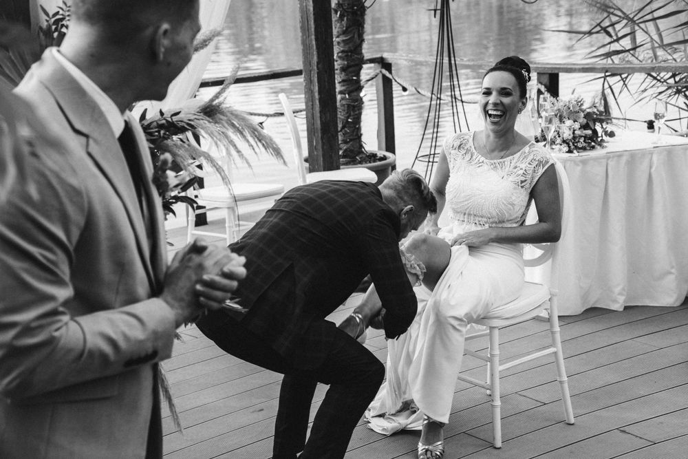 A black and white photo capturing a wedding tradition on an elegant patio setting.