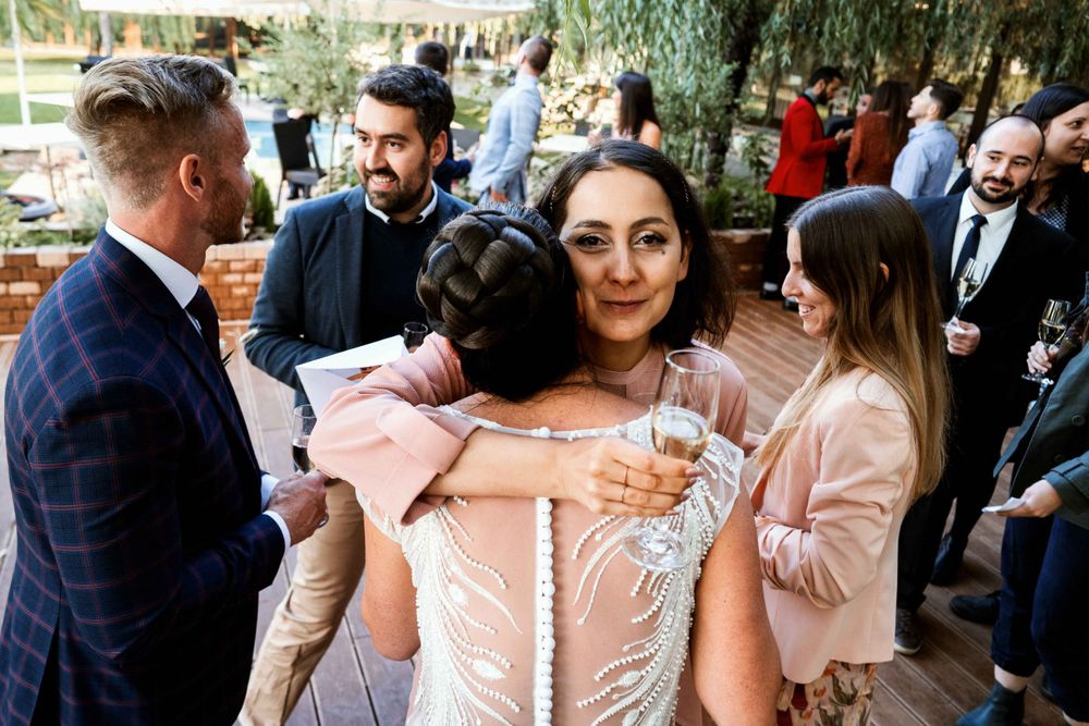 Wedding guests socializing and enjoying drinks at an outdoor reception.