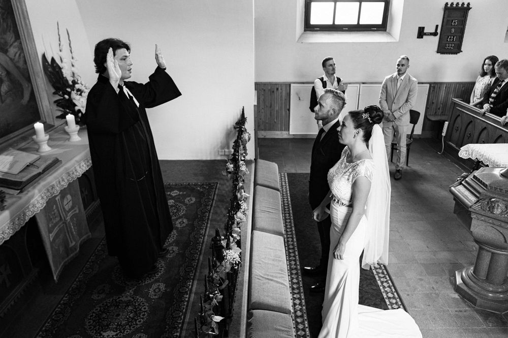 Black and white photo of a church wedding ceremony with clergy officiating.