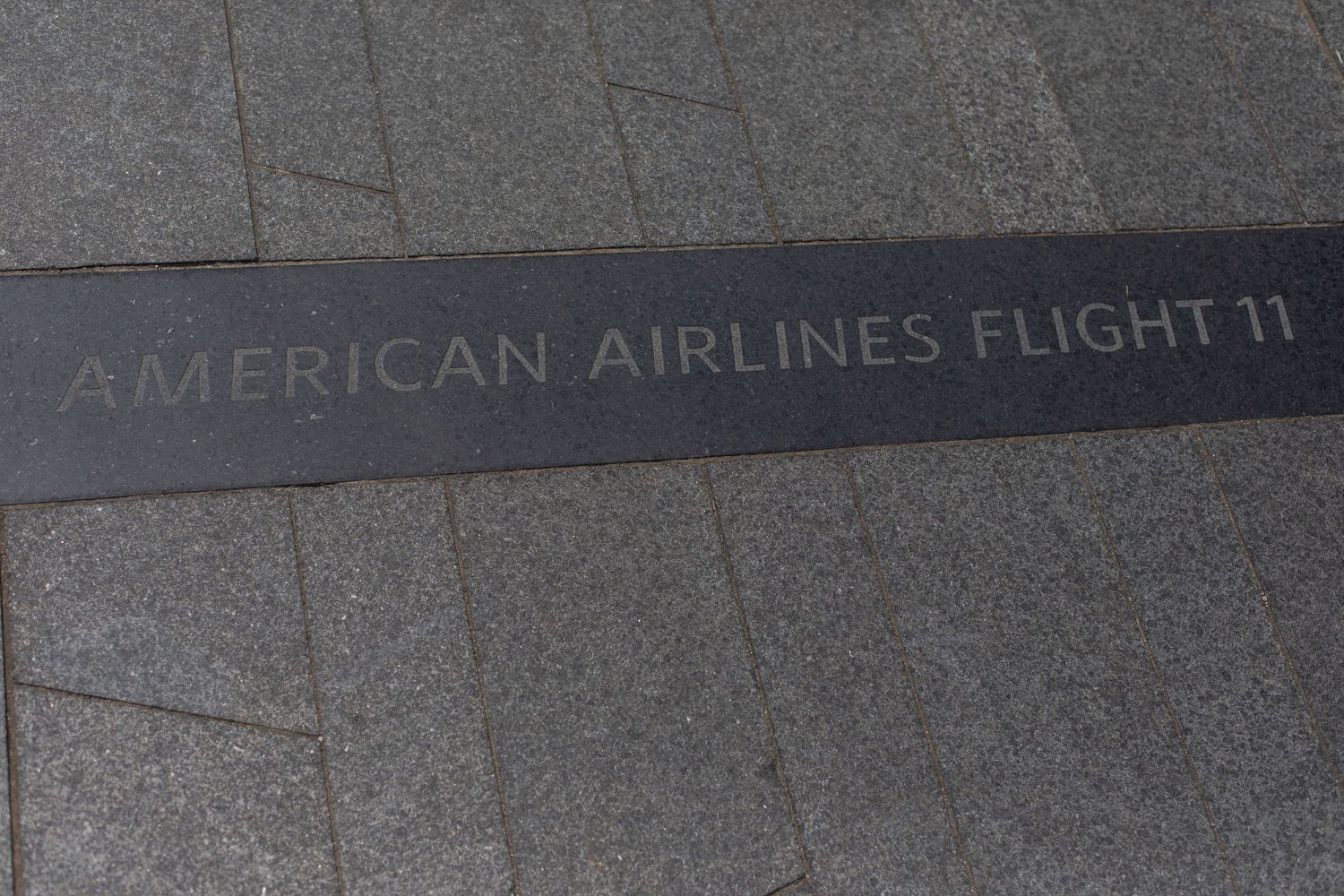 Memorial text commemorating American Airlines Flight 11 carved in stone.