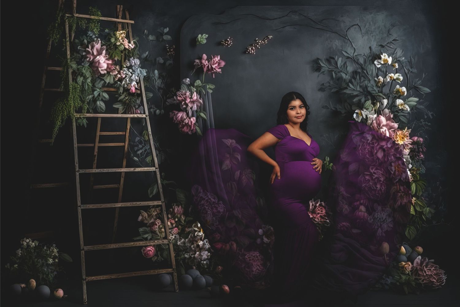 Moody maternity portrait with vintage ladder and floral arrangements against dark backdrop.