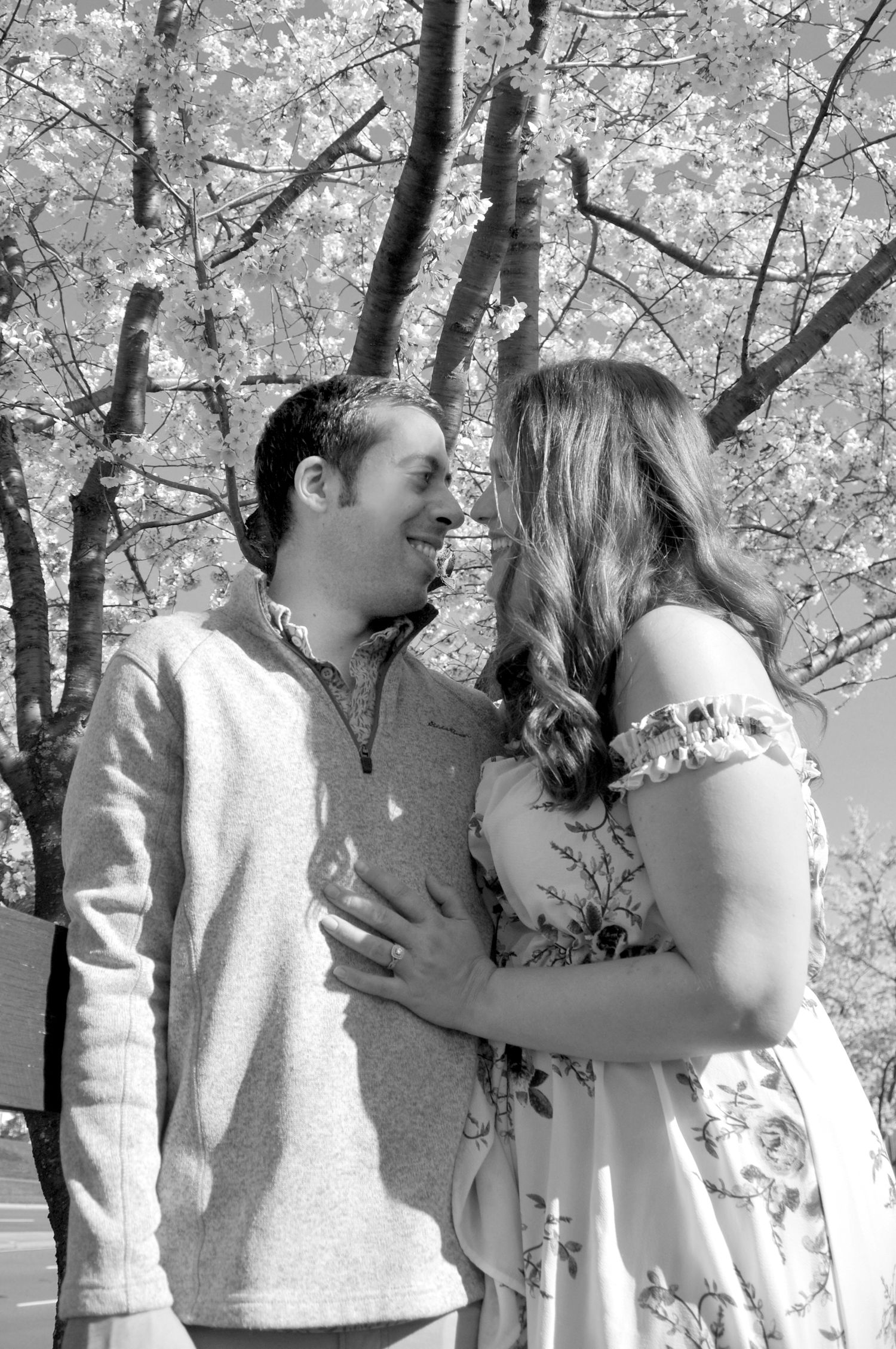black and white photo of couple near blossoming tree