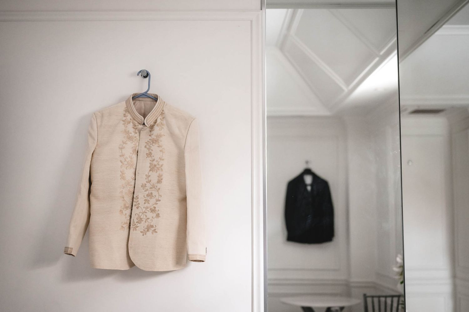 Wedding attire and accessories displayed on hangers in a bright dressing room.