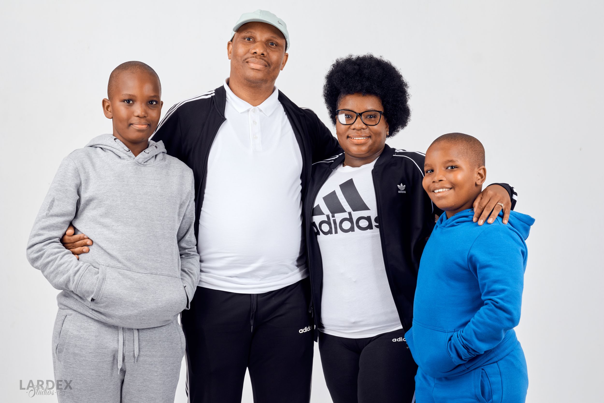 Studio portrait of four people in casual sportswear against white background.