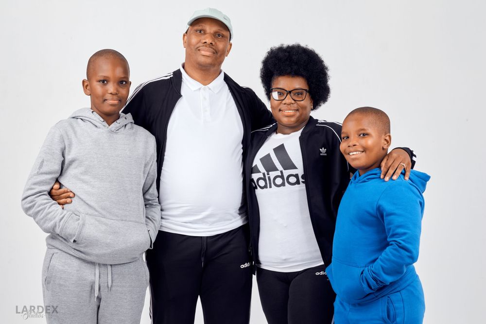Studio portrait of four people in casual sportswear against white background.