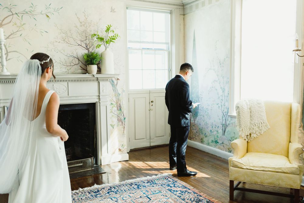 Wedding day preparations in a light-filled room with floral wallpaper and vintage furnishings.