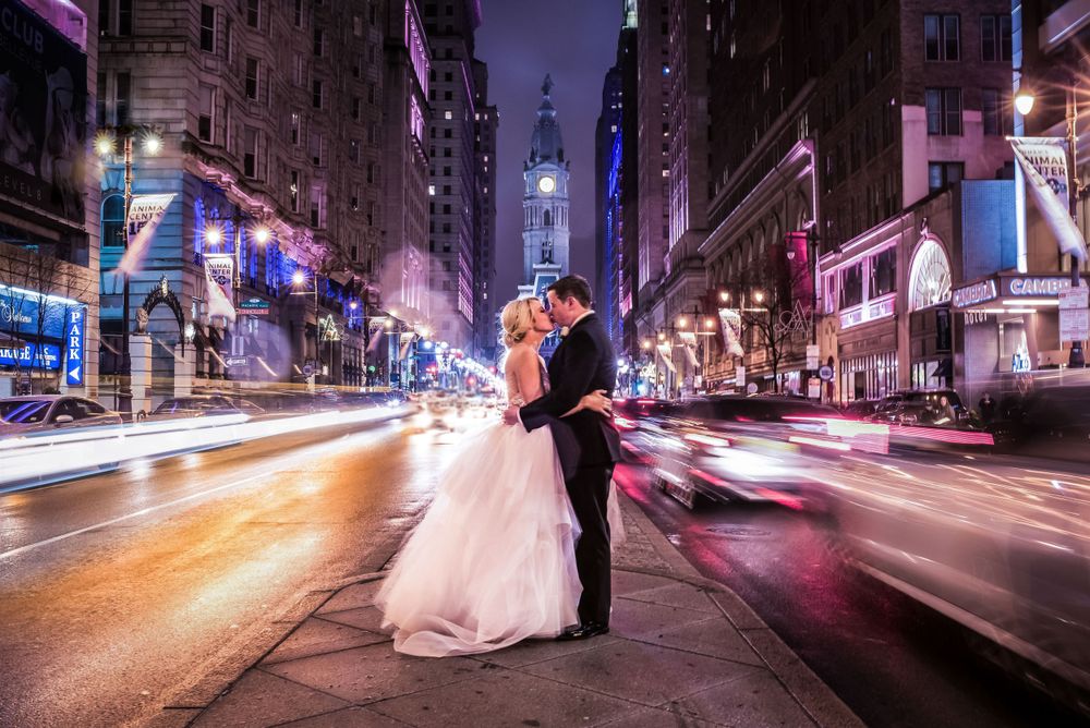 Dramatic nighttime wedding photo with light trails on Broad Street in Philadelphia.