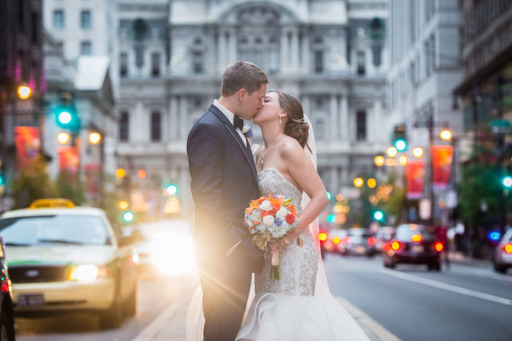 Wedding portrait on Philadelphia city street with City Hall in background at dusk.