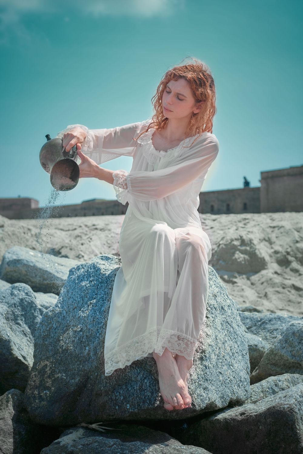 A ghostly woman holding a pitcher with sand falling out of it.