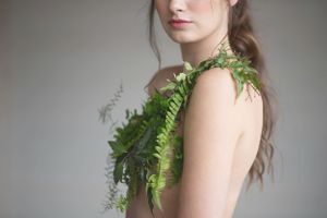 Artistic portrait featuring natural ferns draped across bare shoulders in a minimalist  at Sanctuary Gardens, Kelowna B.C.