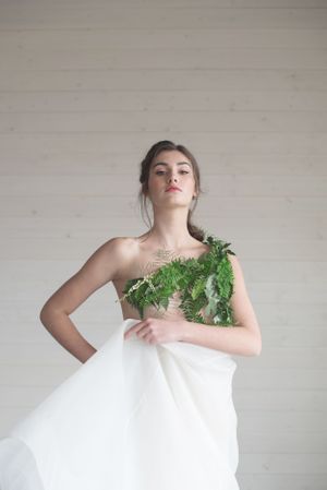 Artistic bridal portrait with model draped in white fabric and adorned with green ferns at Sanctuary Gardens, Kelowna B.C.