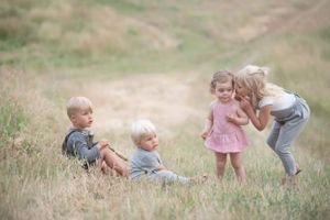 Sweet outdoor scene of children playing together in a golden field in Penticton, B.C.
