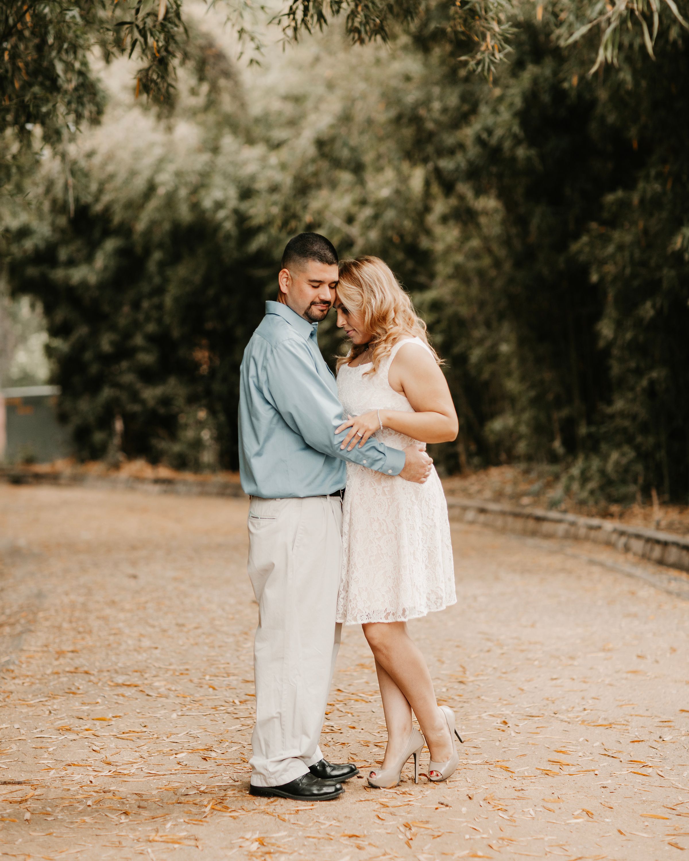 Intimate couple's photoshoot moment captured on rustic outdoor path.