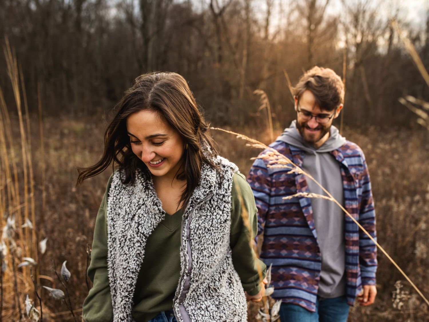 couple walking out of field at sunset