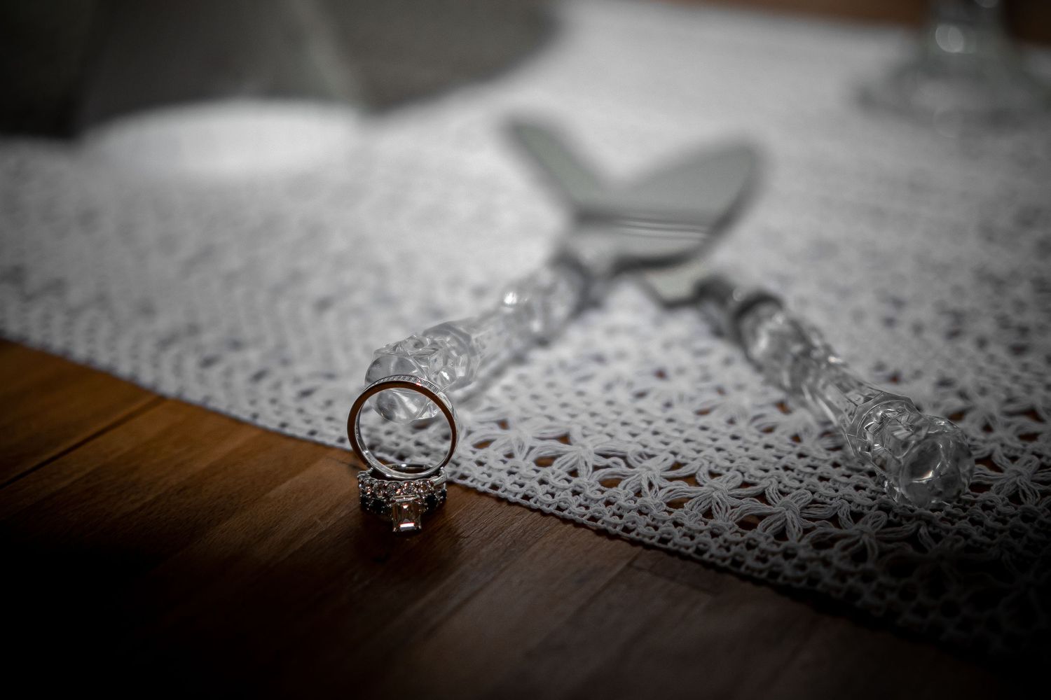 Wedding rings on a textured lace surface with artistic shallow depth of field.