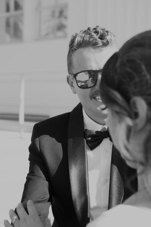 A black and white photo of a formal event showing someone in sunglasses and a bowtie.