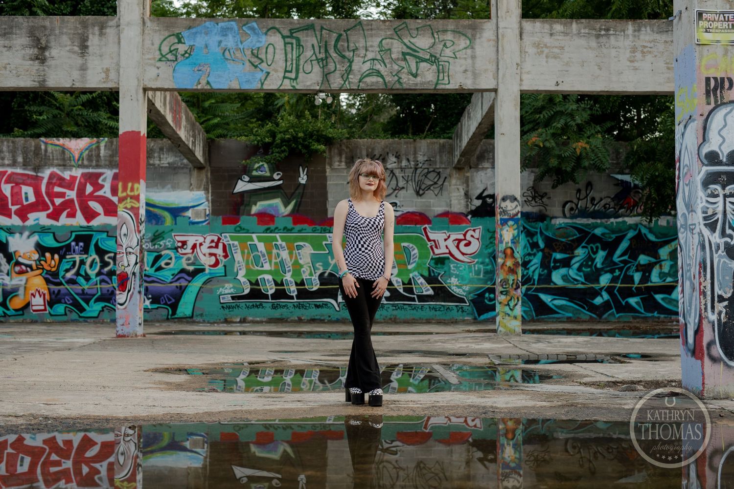Fashion portrait in urban setting with graffiti walls and concrete structures as backdrop.
