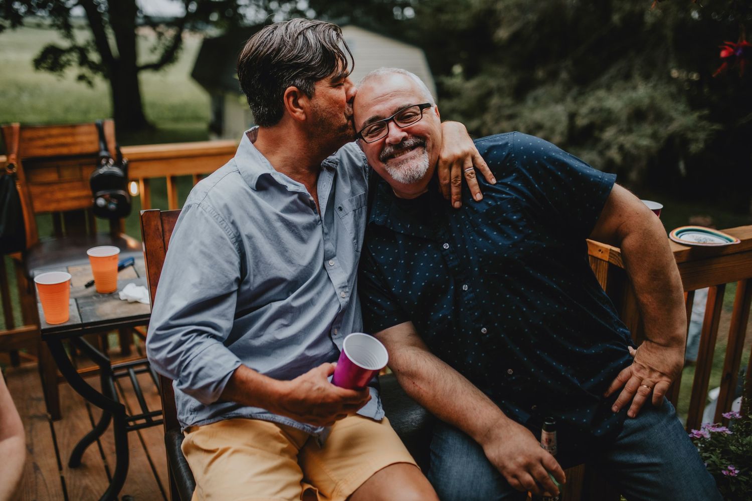 a man kissing his best friend on the head
