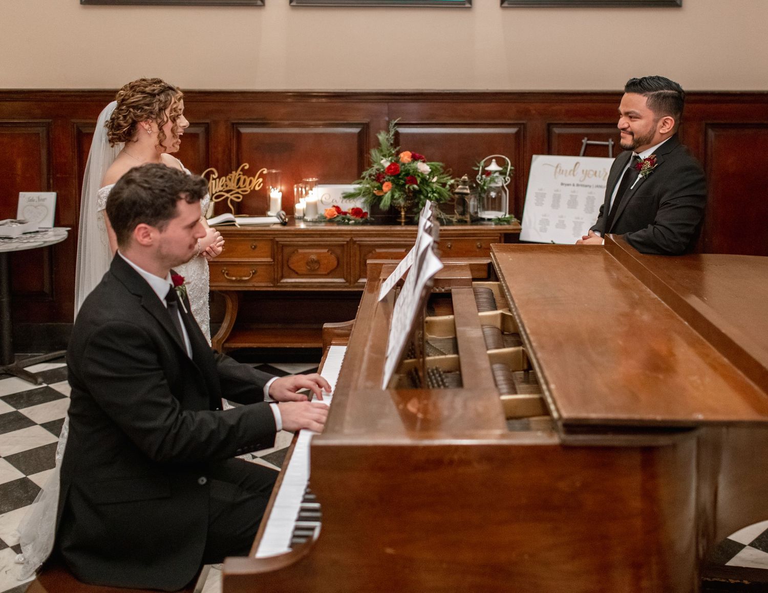 Wedding ceremony scene with pianist playing at a grand piano in an elegant wood-paneled room.