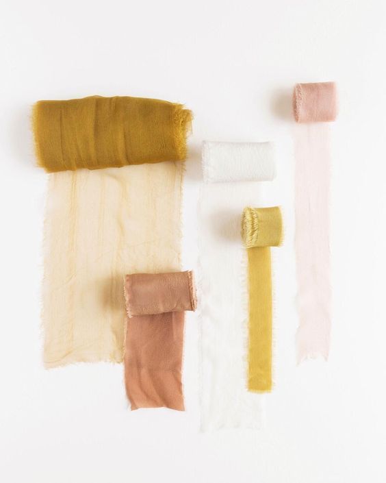 Paper swatches displaying a warm color palette with mustard yellow, blush pink, and cream tones laid out horizontally.