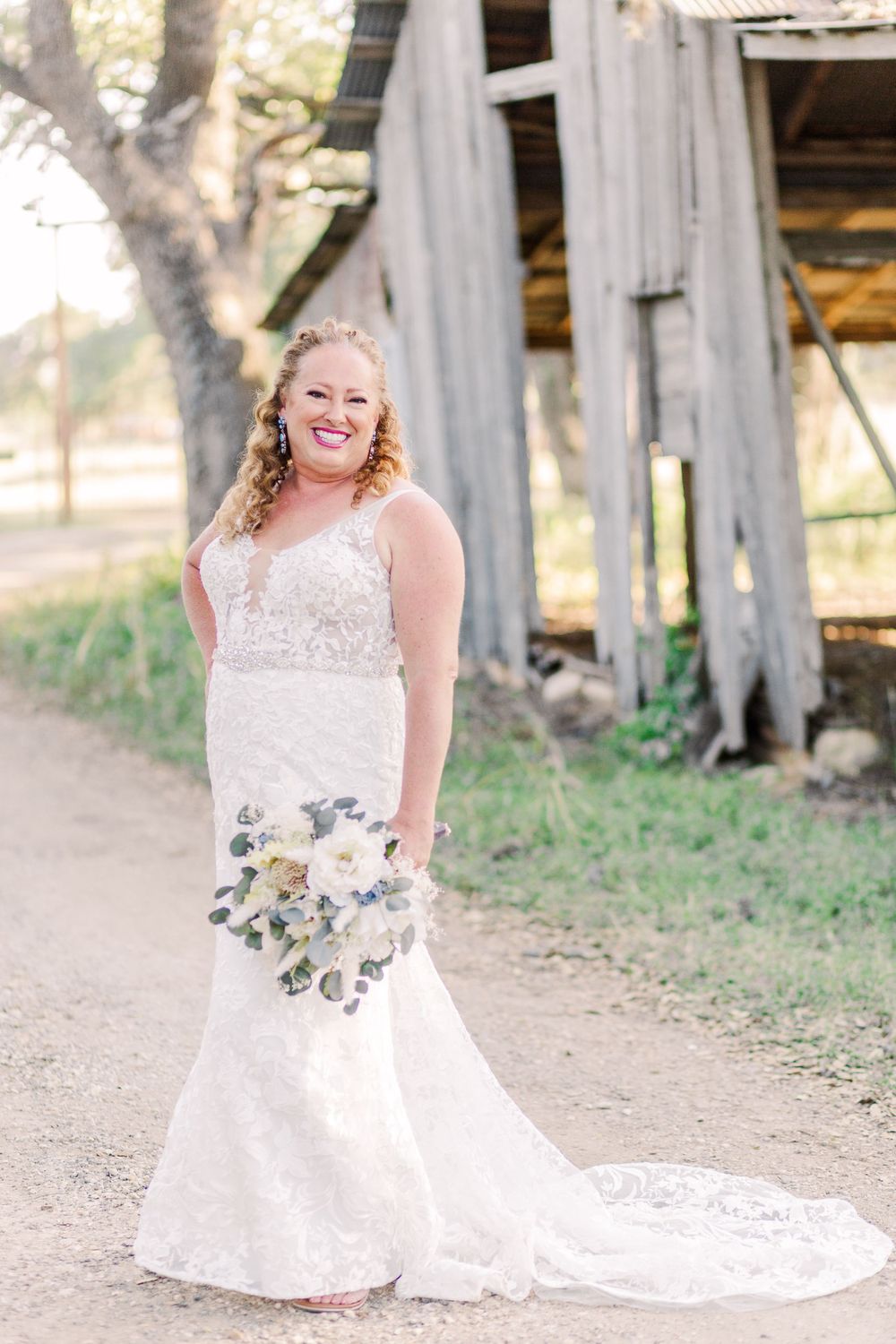 A bridal portrait series against rustic wooden walls showcasing a lace wedding gown and floral bouquet.