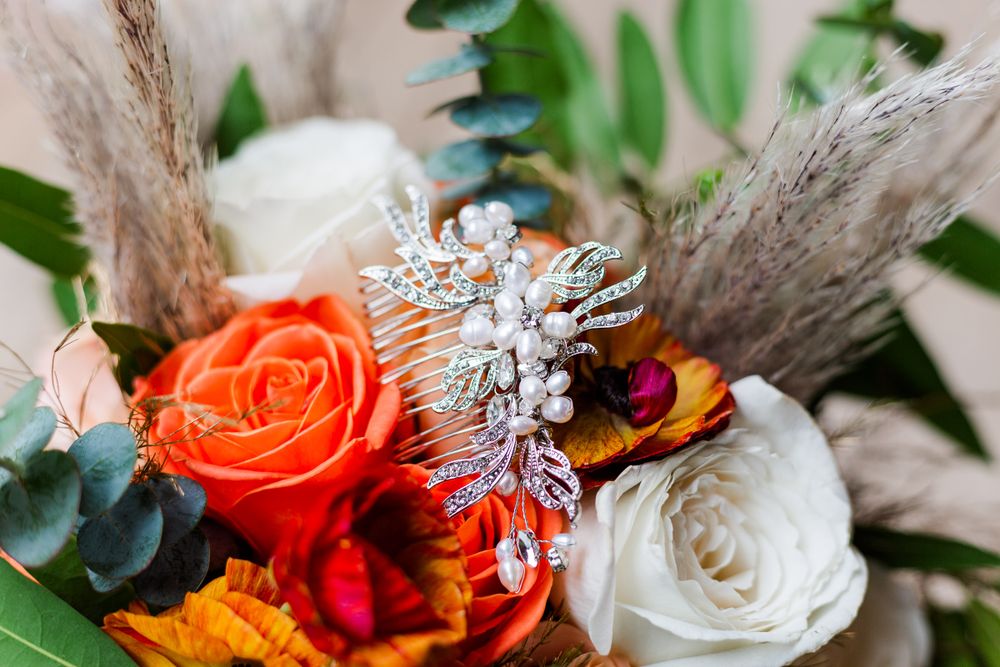 Wedding detail shot of orange and red floral arrangements with crystal accessories, by best San Antonio Photographer.